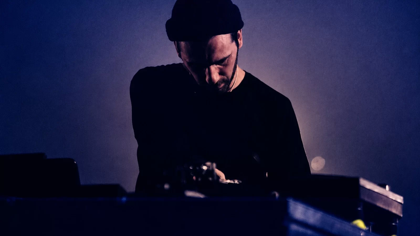 Jay Glass Dubs performing under cool blue stage light.