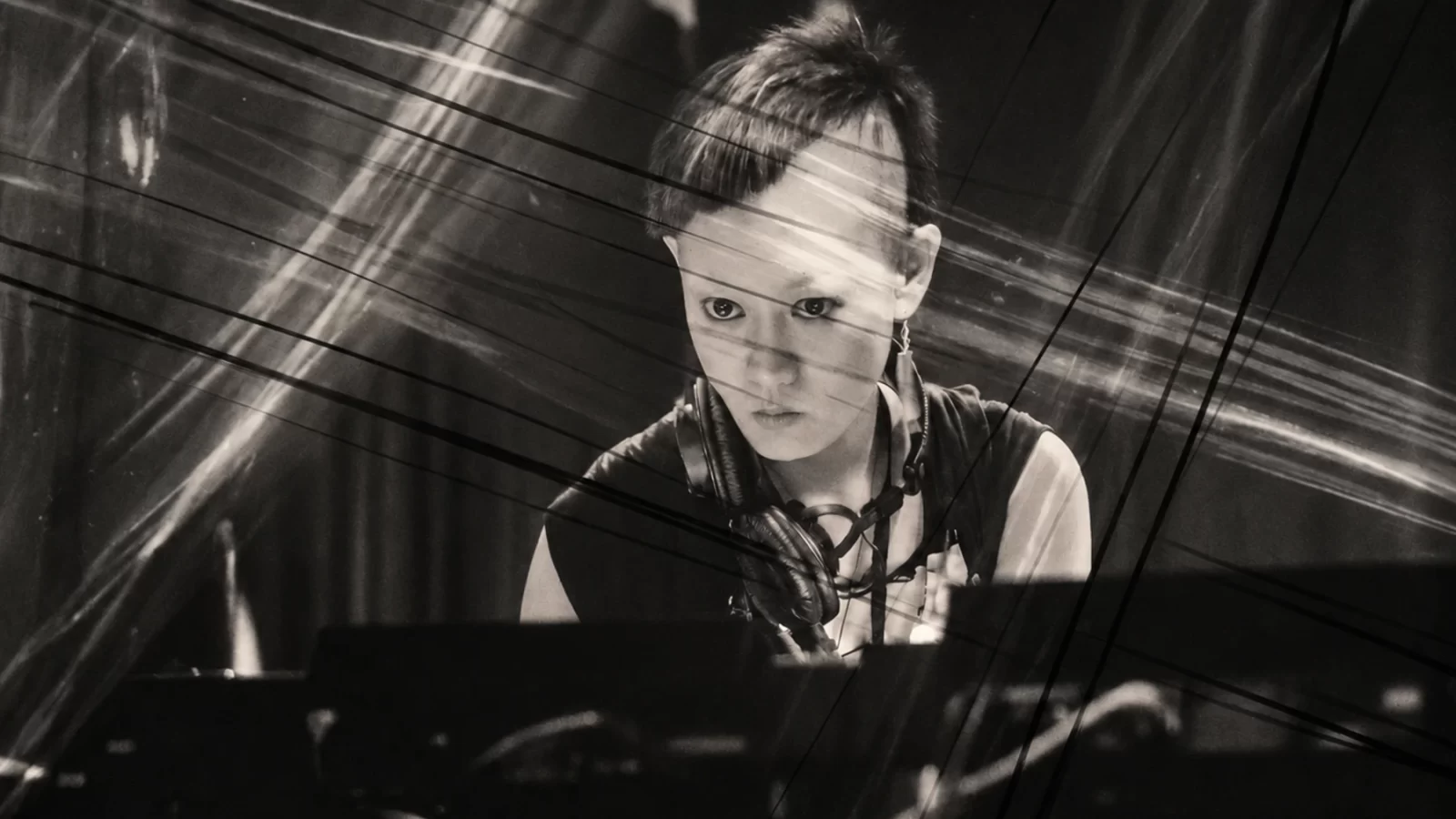 Mieko Suzuki performing amid intersecting trails of light.