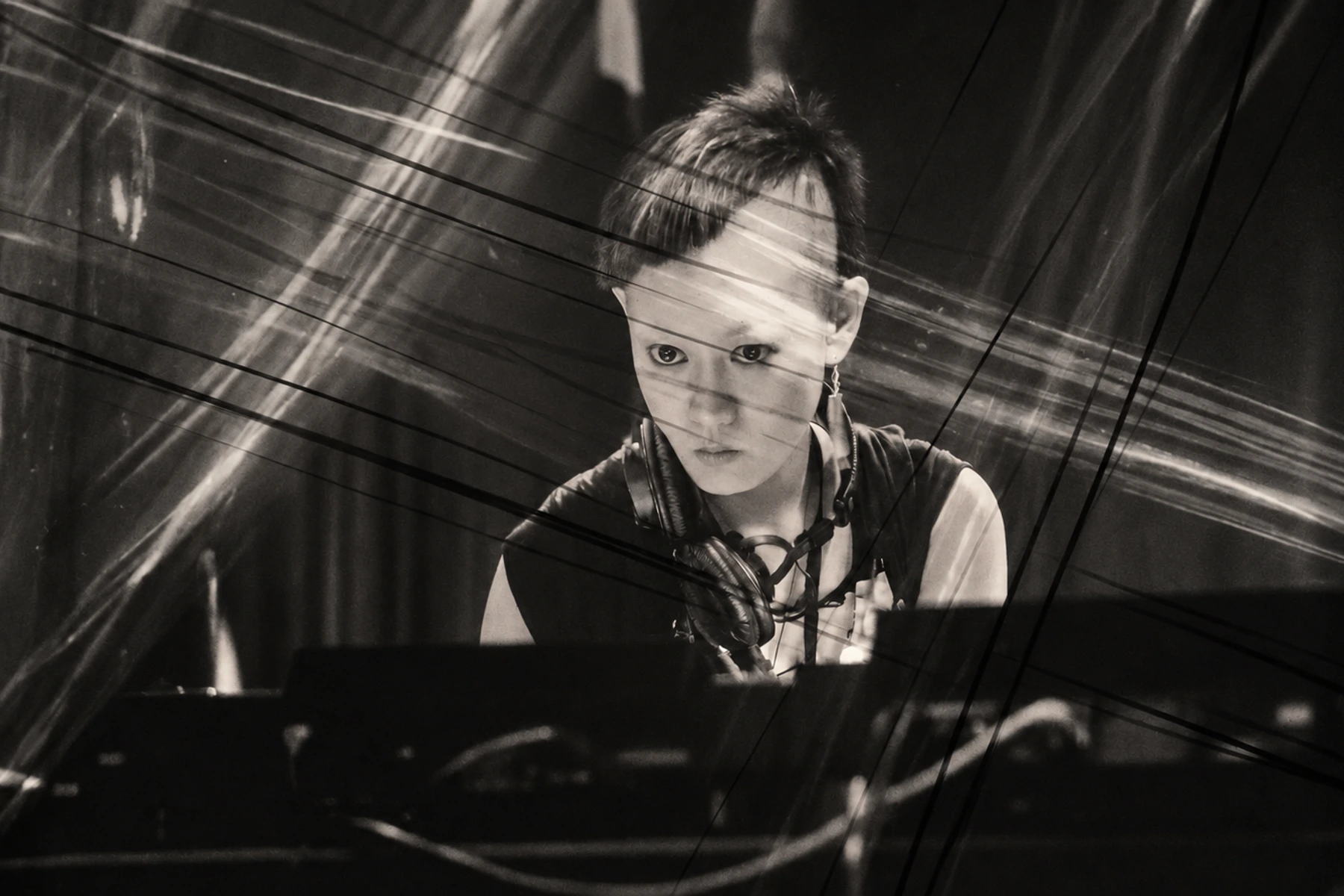 Mieko Suzuki performing amid intersecting trails of light.
