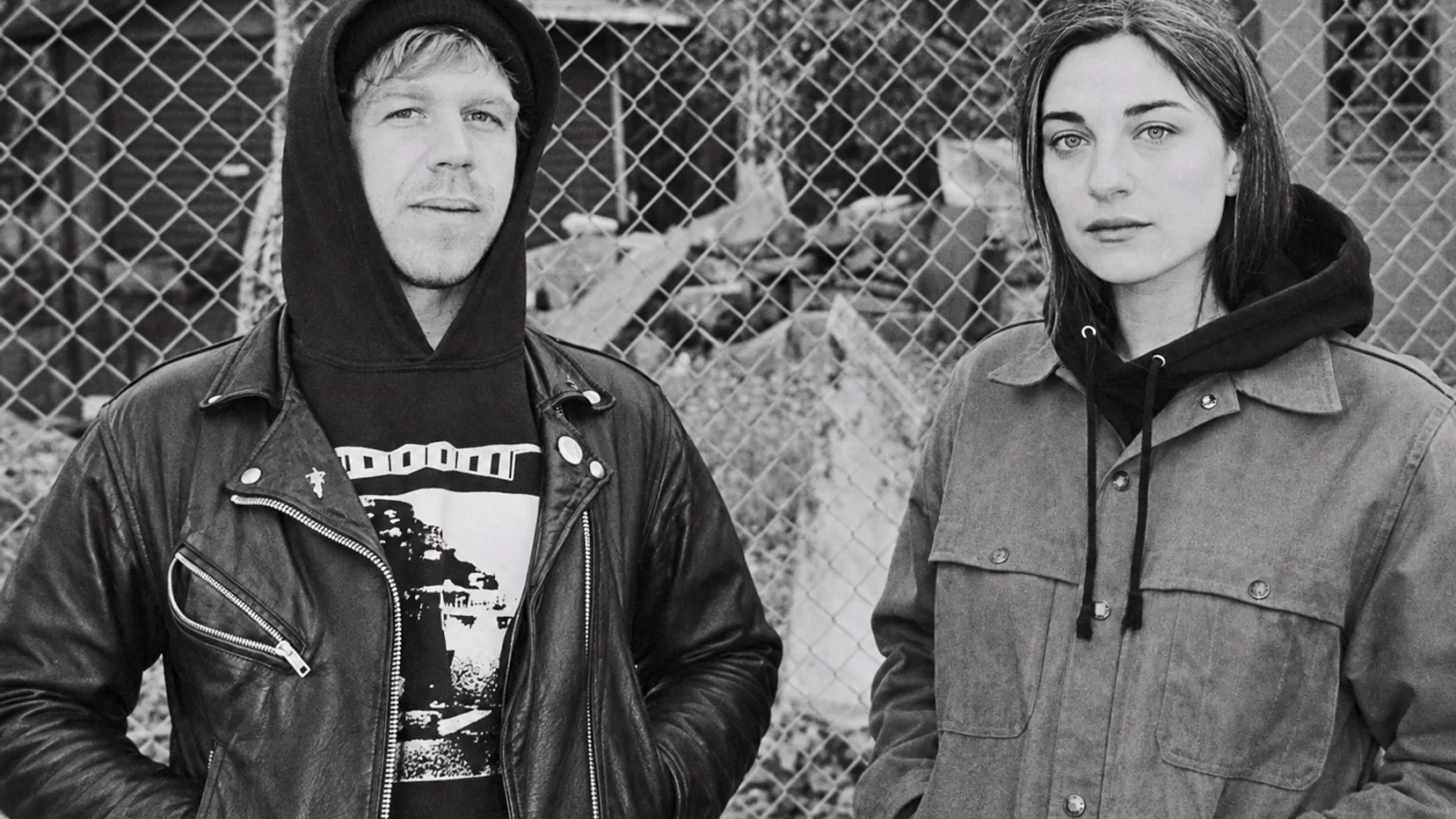 A.M. Rehm and Kali Malone / Sorrowing Christ standing before a chain-link fence.