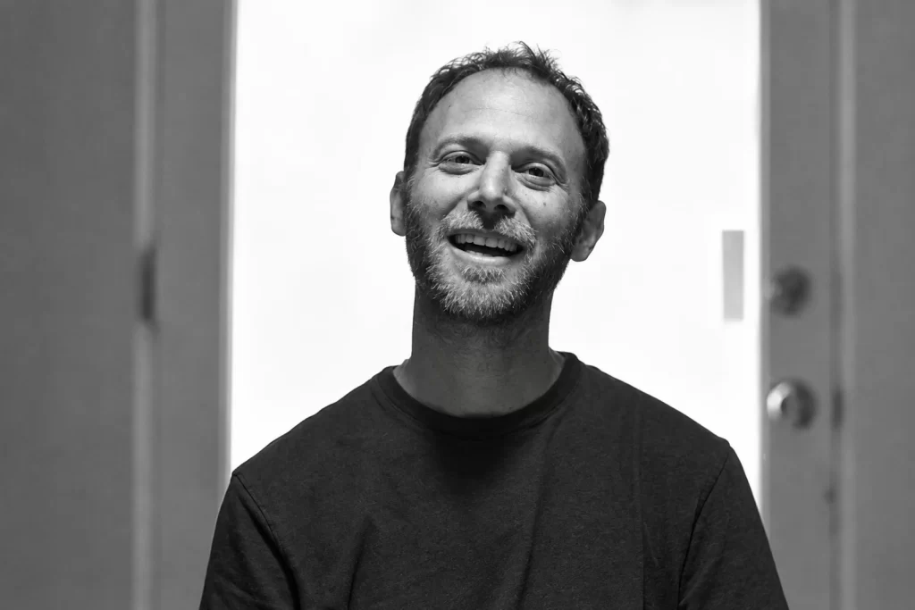Steve Roden smiling in a doorway in Pasadena in 2009.