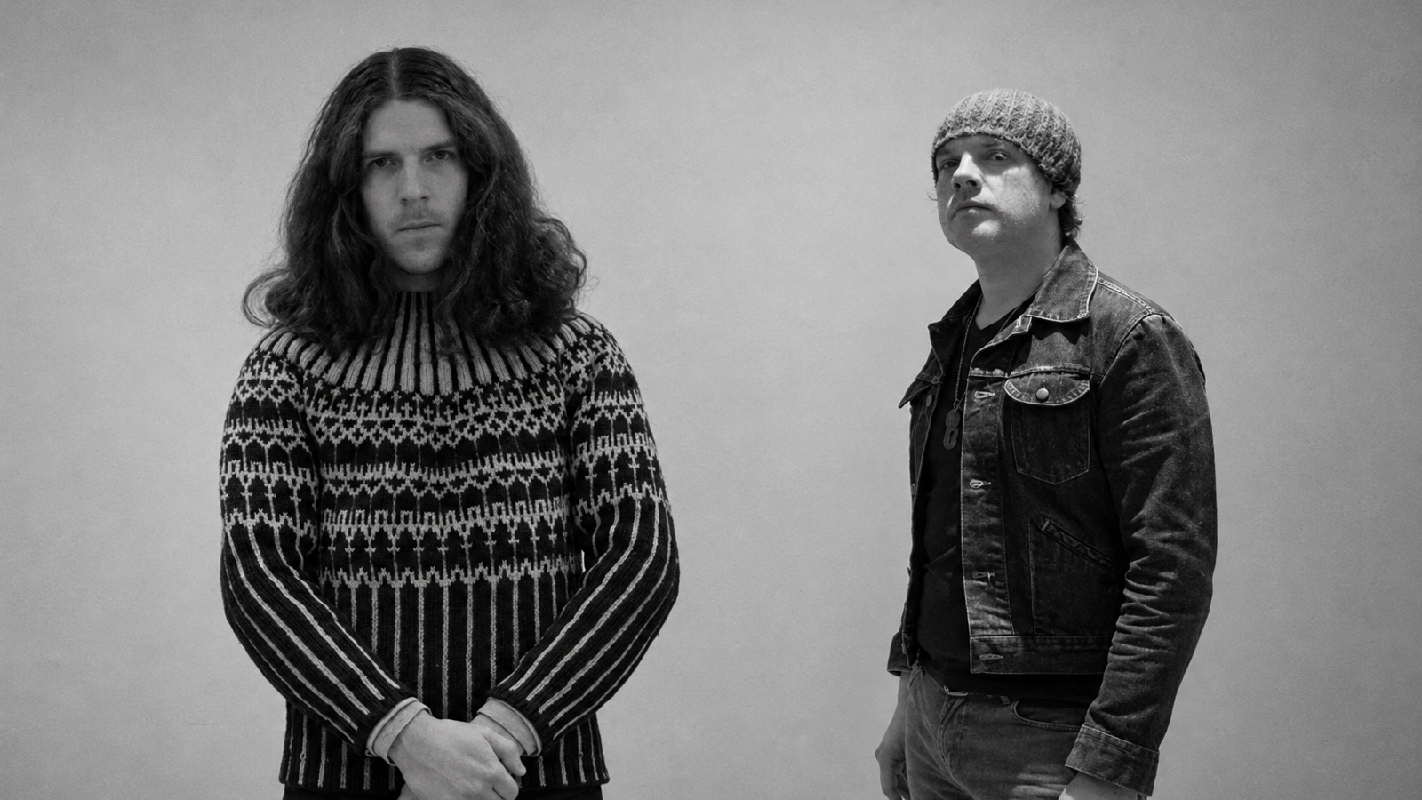 Mark Van Hoen and Louis Sherman of Locust standing against a textured wall in a restored monochrome portrait.