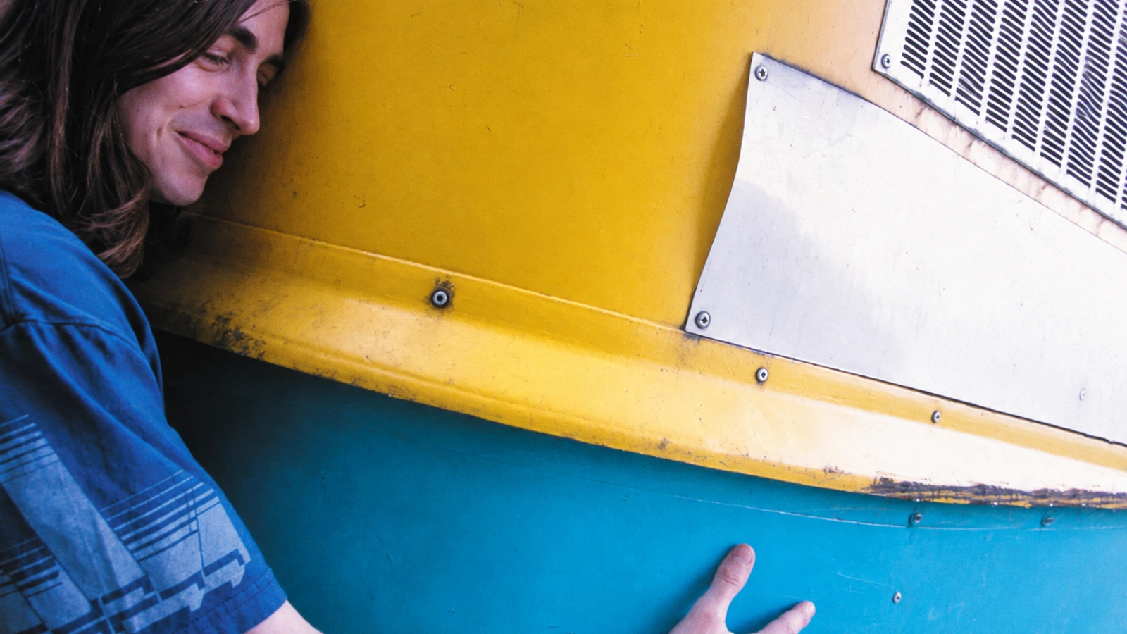 Quinoline Yellow beside a yellow and turquoise industrial machine, in a grainy colour photograph.