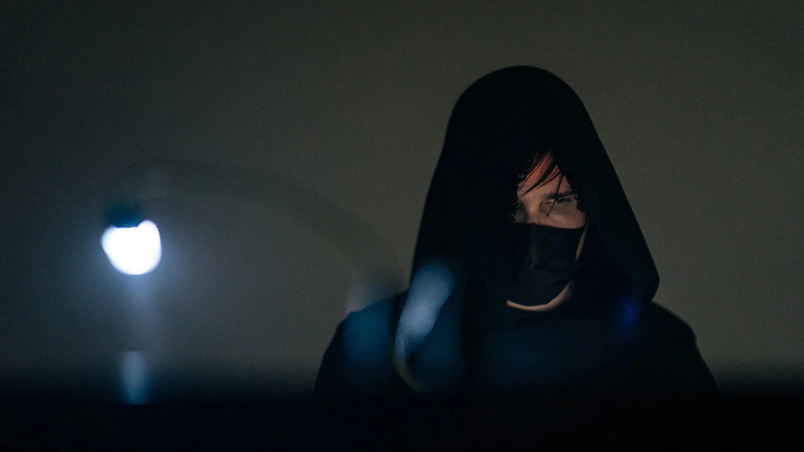 The Sight Below performing under a dark hood, with blue stage lights in the foreground.