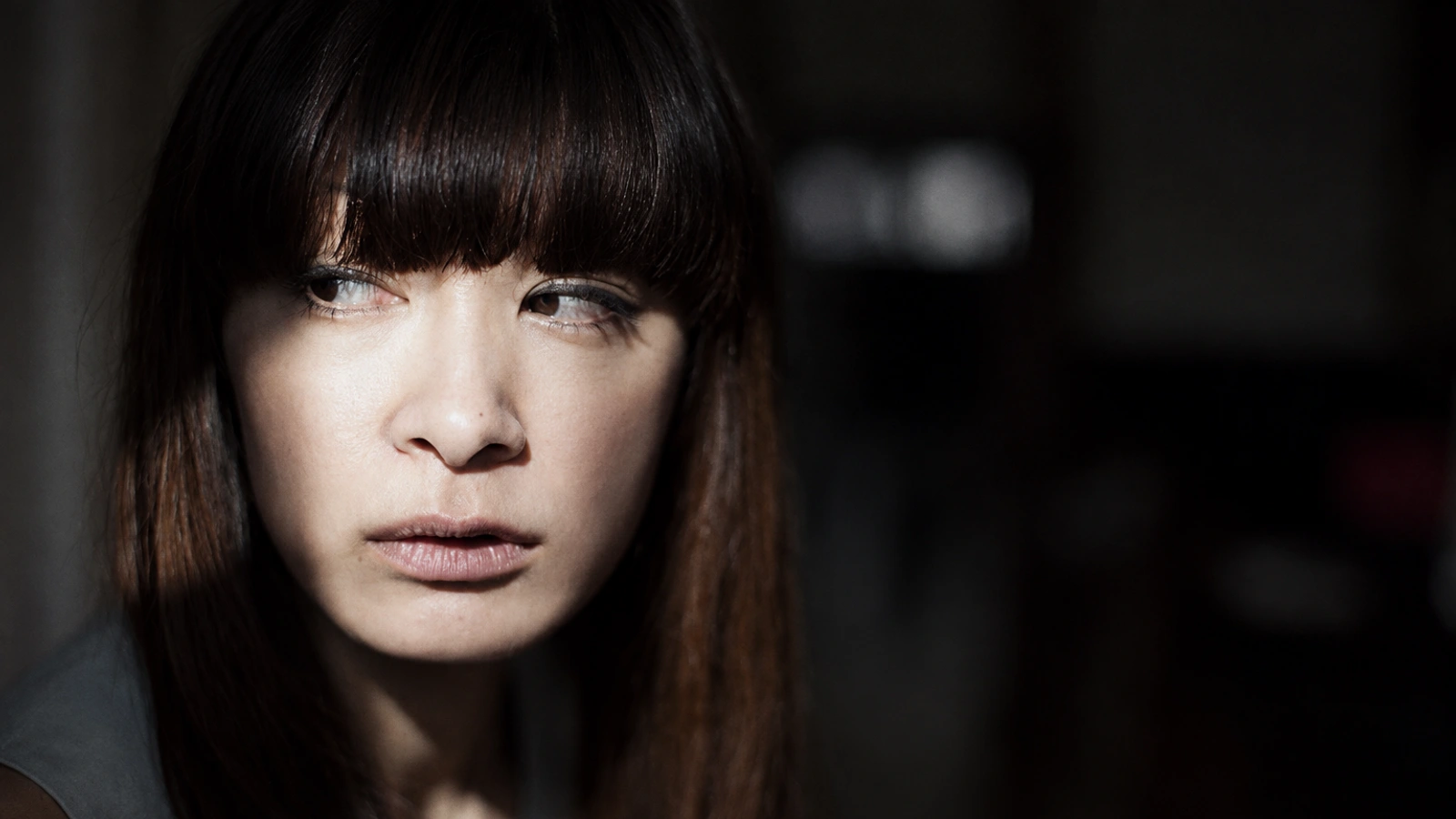 Kyoka in close-up, looking sideways through directional light.