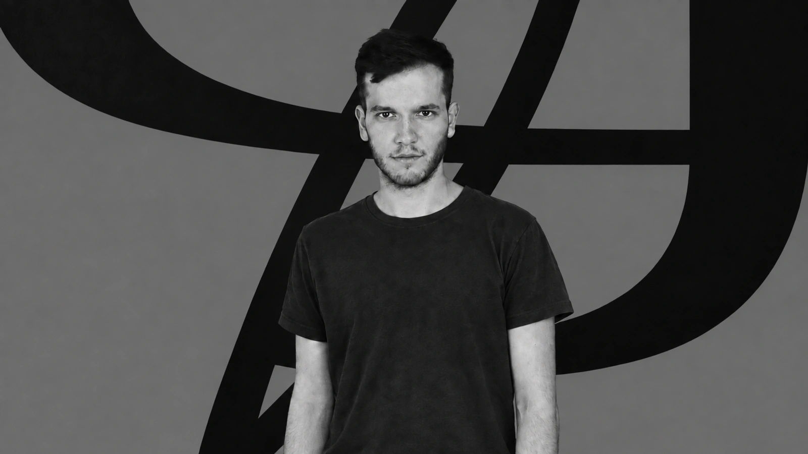 Gábor Lázár in front of a minimalist backdrop of black abstract lines.