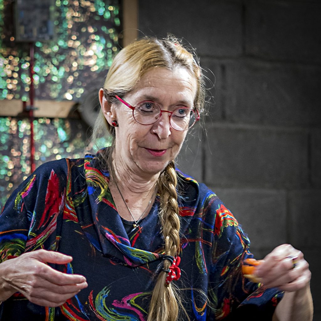Moniek Darge gesturing in a colourful patterned jacket.
