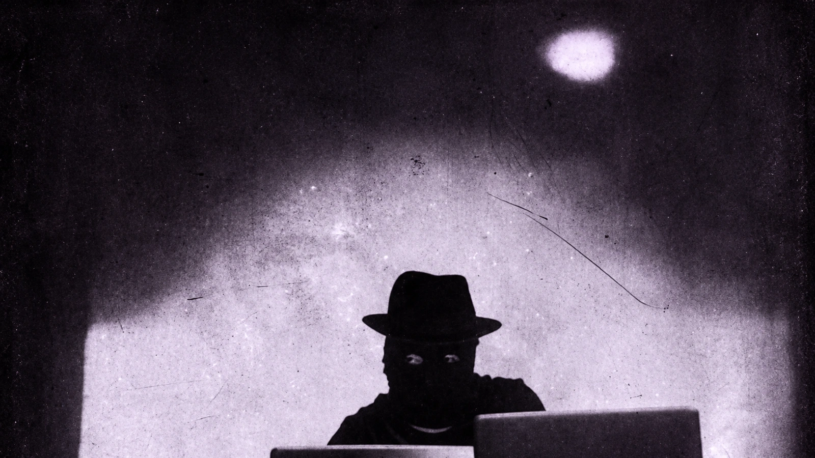 Violet Poison in a dark mask and fedora behind equipment, in a scratched vintage photograph with a subtle violet tint.