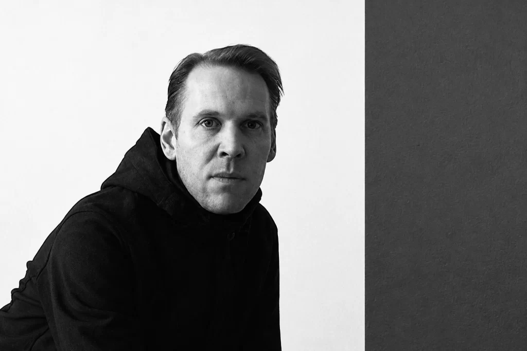 Senking in a monochrome portrait against contrasting pale and dark wall panels.