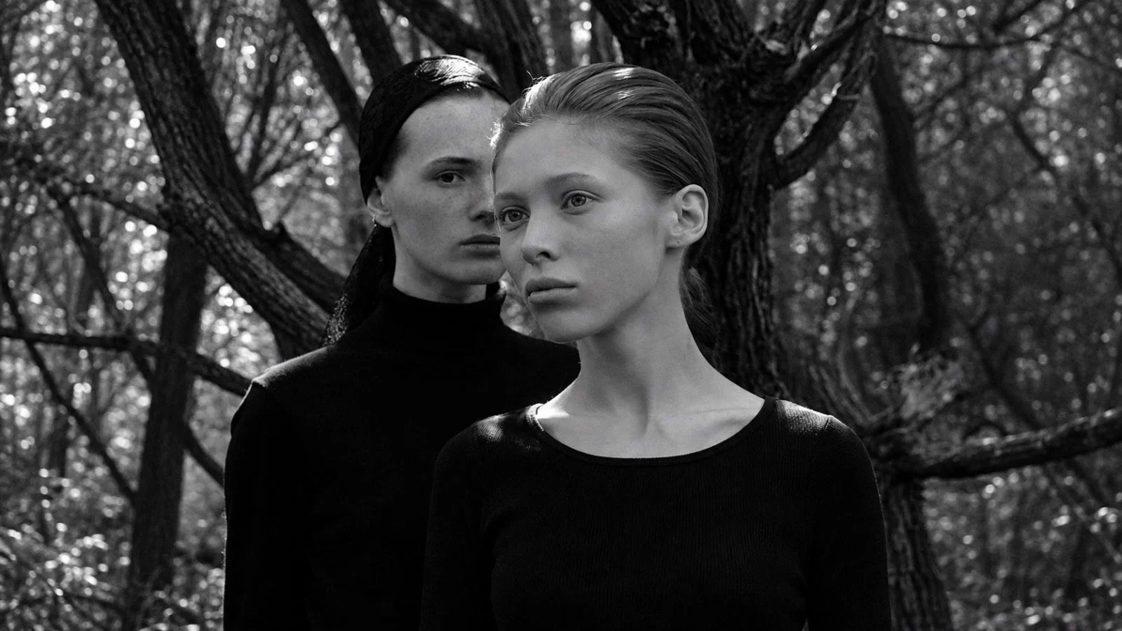 Arigto duo in a black-and-white woodland portrait.