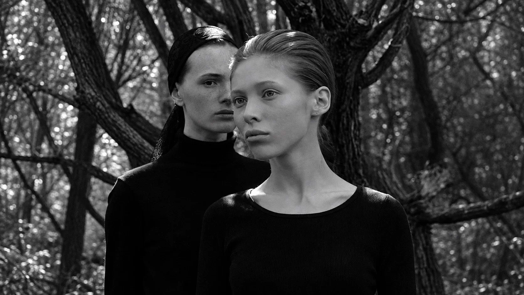 Arigto duo in a black-and-white woodland portrait.
