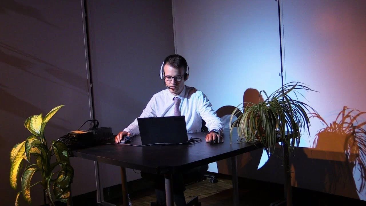 Sam Kidel performing Customer Service Agent at a desk