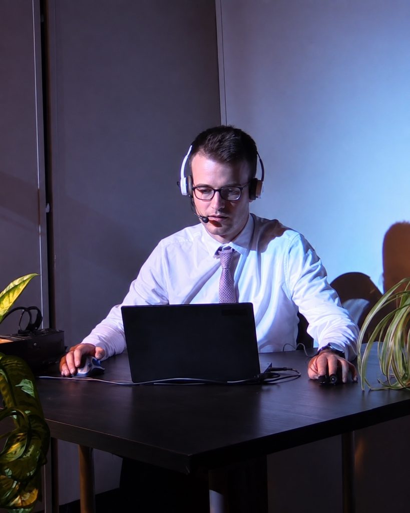 Sam Kidel performing with a headset, laptop and two computer mice