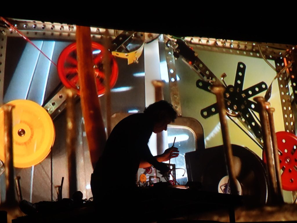 Pierre Bastien performing with a mechanical orchestra and projected shadows