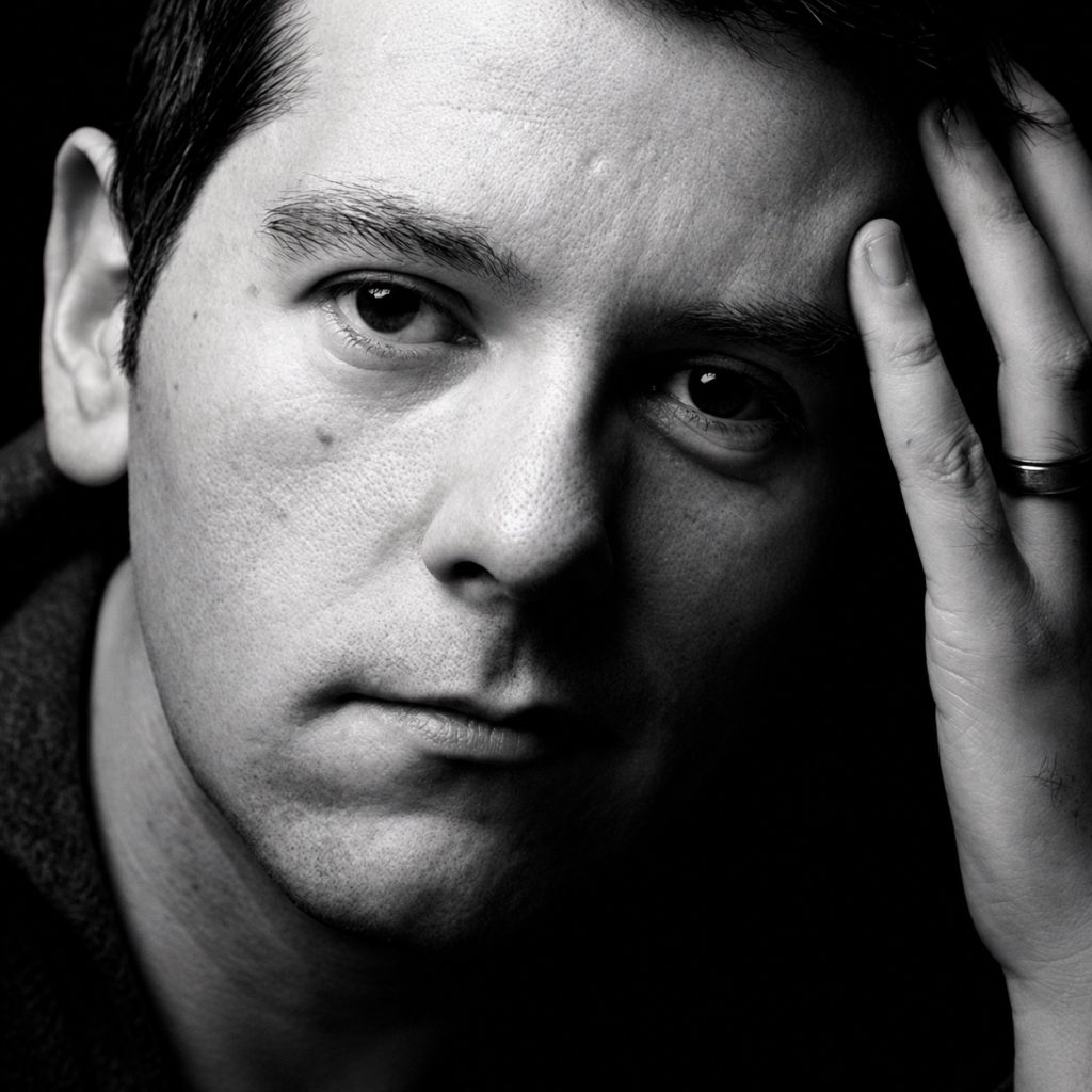 James Clements of ASC in a close portrait with his hand against his forehead