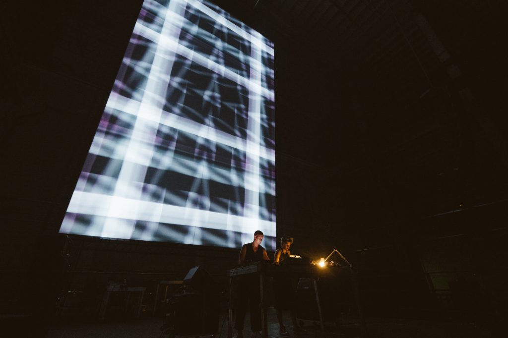 COH and Tina Frank performing in front of a video projection