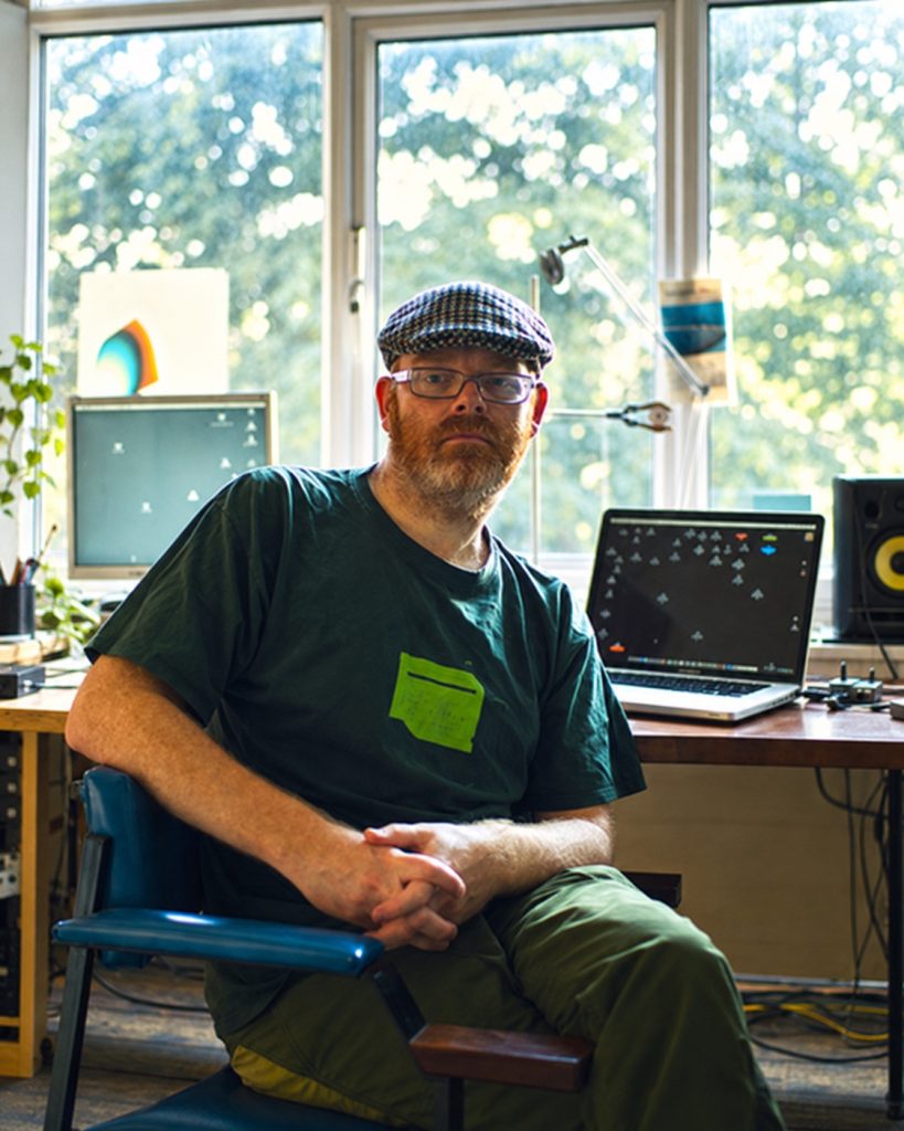 Mark Fell seated in his studio