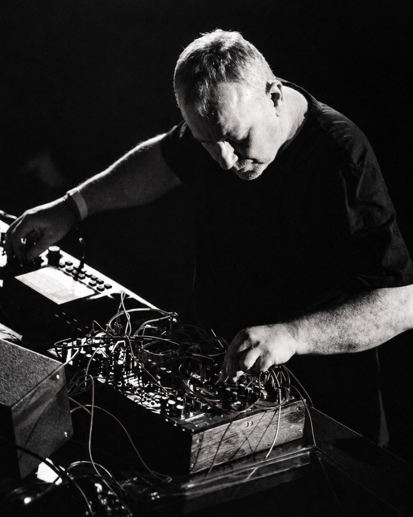 Drew McDowall performing with a modular synthesizer