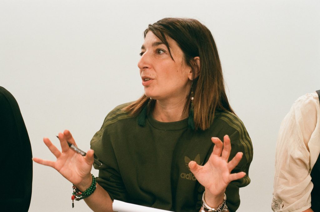 Mira Calix speaking with her hands raised during a discussion at Frieze London.