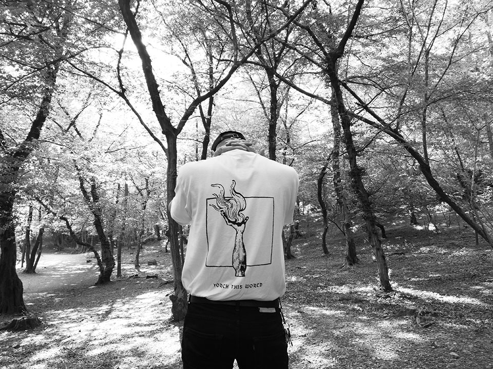 Andrea Napoli standing in a wooded landscape wearing an Avant! Records shirt.